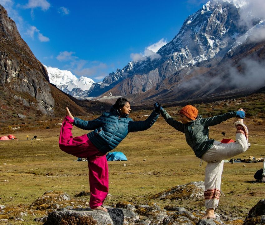Travelers enjoying outdoor yoga amidst high-altitude mountain landscapes during a Nubra Valley Ladakh tour.