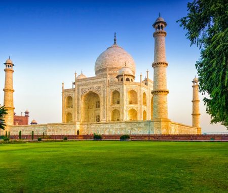Taj Mahal in Agra, India, with green gardens and four minarets