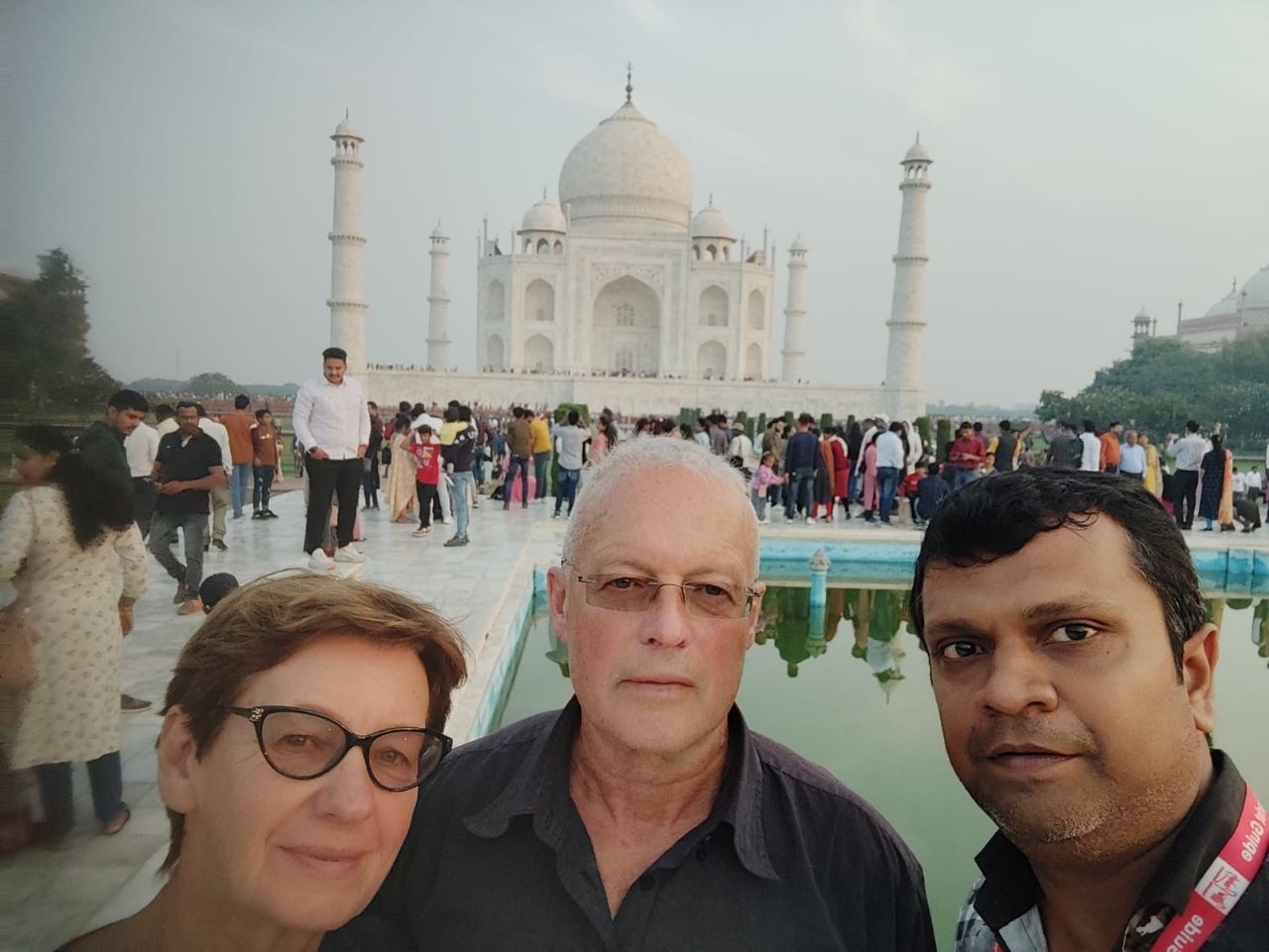 Visitors and their local tour representative posing in front of the Taj Mahal in Agra