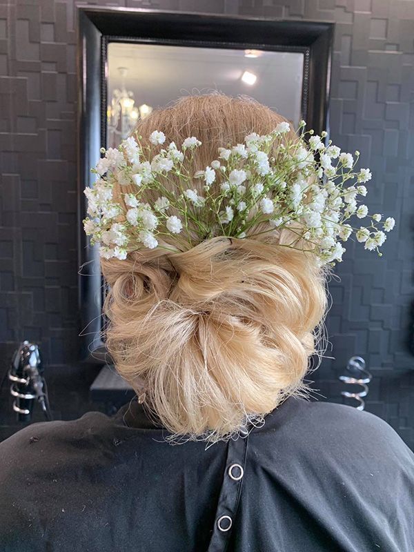 A Woman Is Wearing a Bun with Baby's Breath in Her Hair — Capello Hair Design in Port Macquarie, NSW