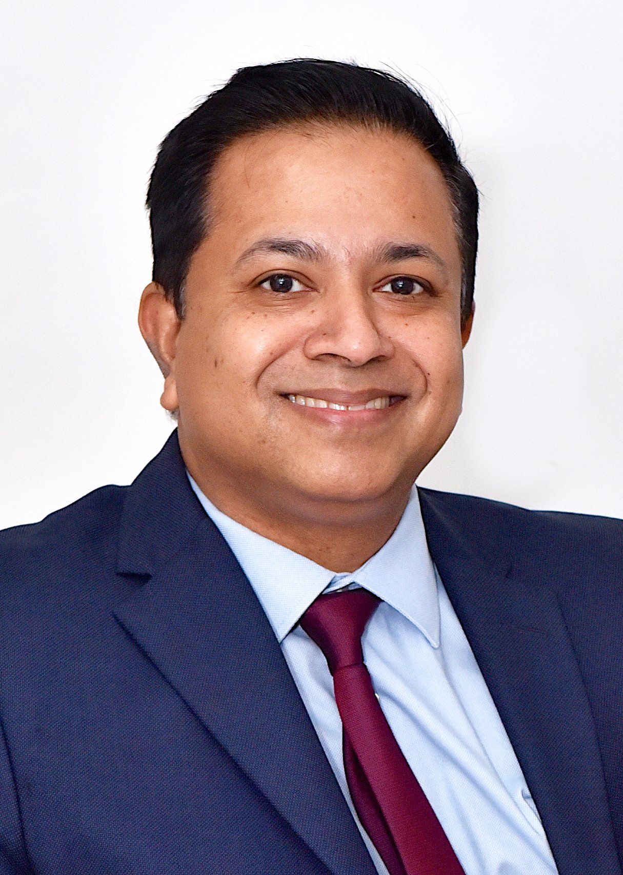 A man in a suit and tie is smiling for the camera.