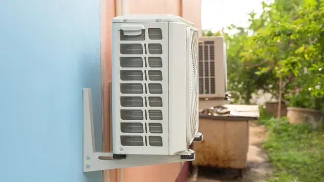 Air conditioning unit mounted on a blue and pink wall, set against a blurred outdoor background.