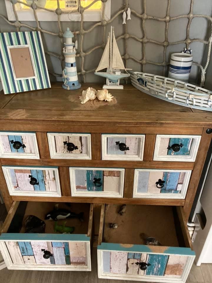 A wooden dresser with drawers and a lighthouse on top
