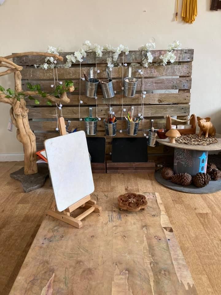 A wooden table with a painting easel in a room.