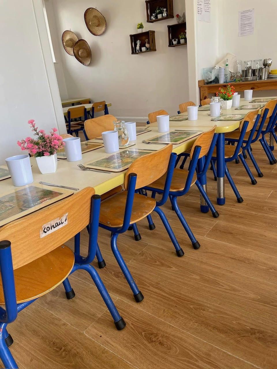 A long row of tables and chairs with flowers on them