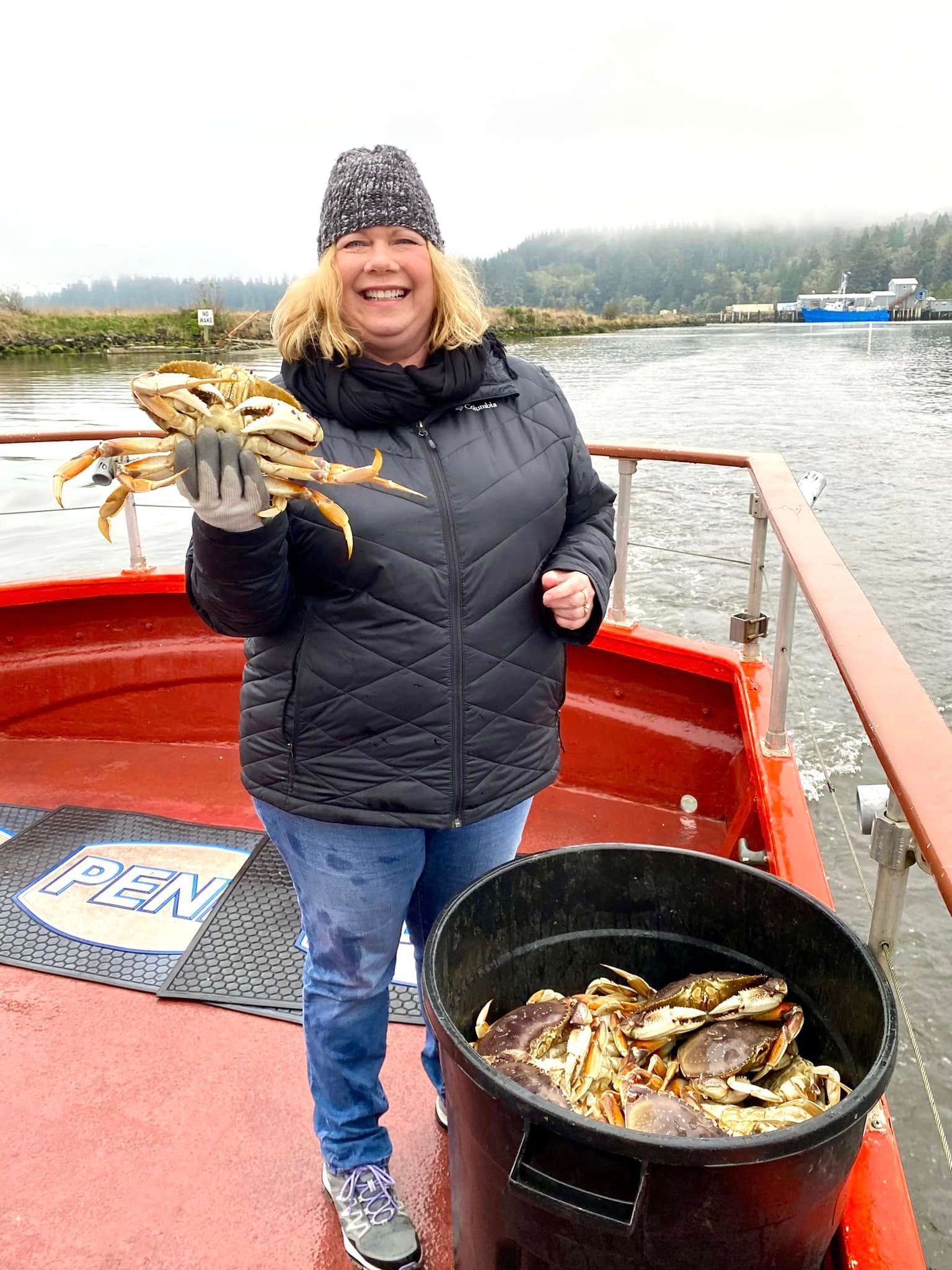 A woman is holding a bunch of crabs on a boat.