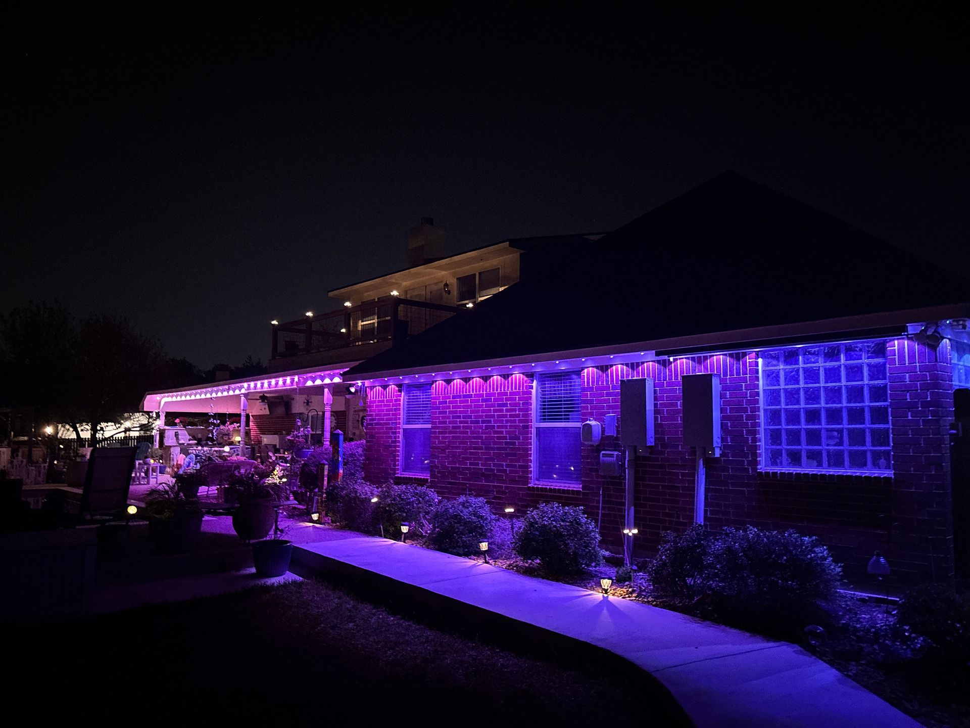 House exterior lit with purple holiday lights at night