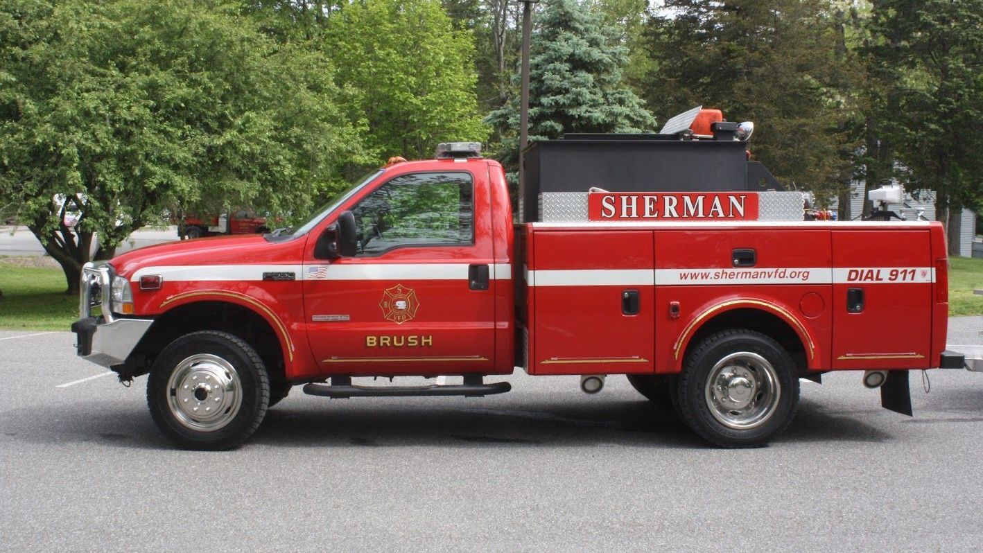 A red sherman fire truck is parked on the side of the road