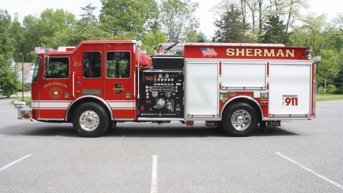 A sherman fire truck is parked in a parking lot