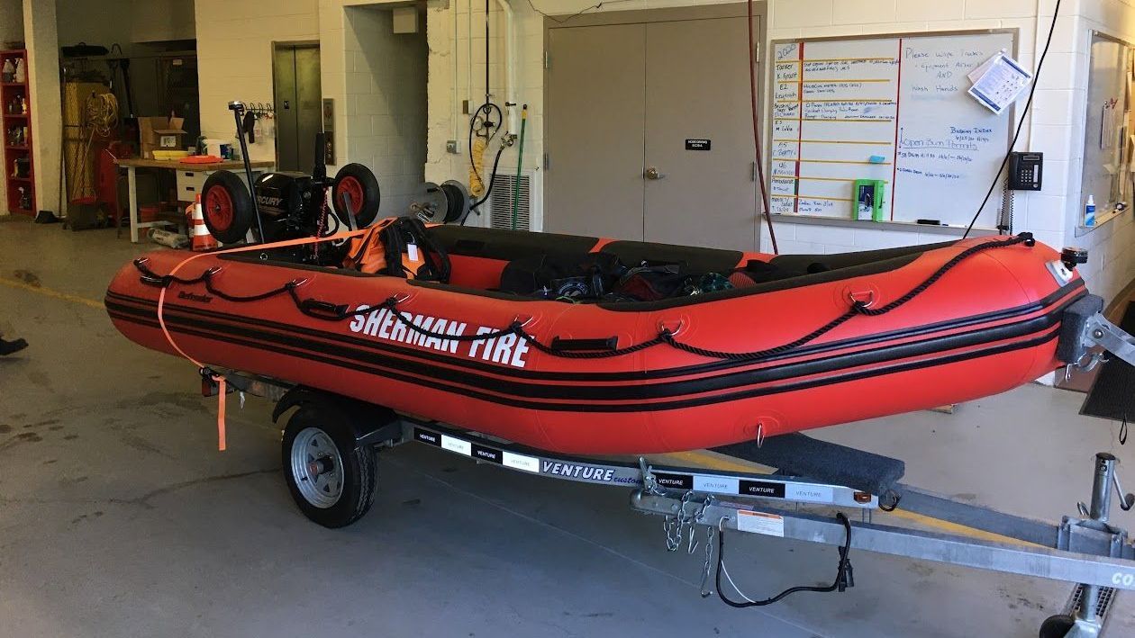 A red raft is on a trailer in a room.