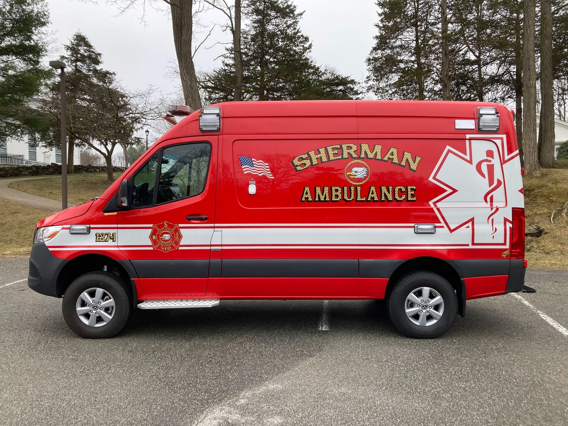 A red ambulance is parked in a garage.