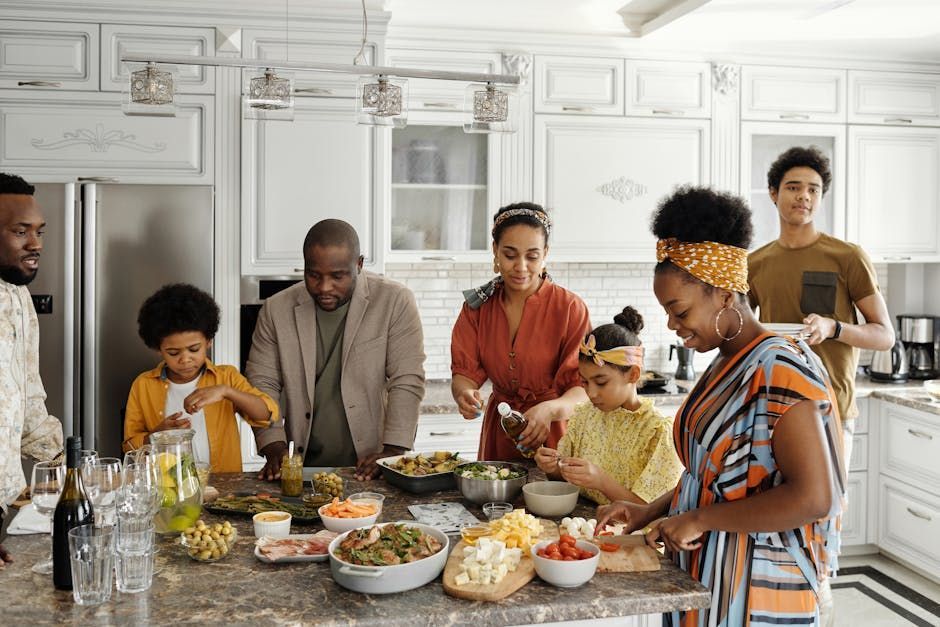 Family gathered around a kitchen island preparing and serving food in a bright white kitchen.