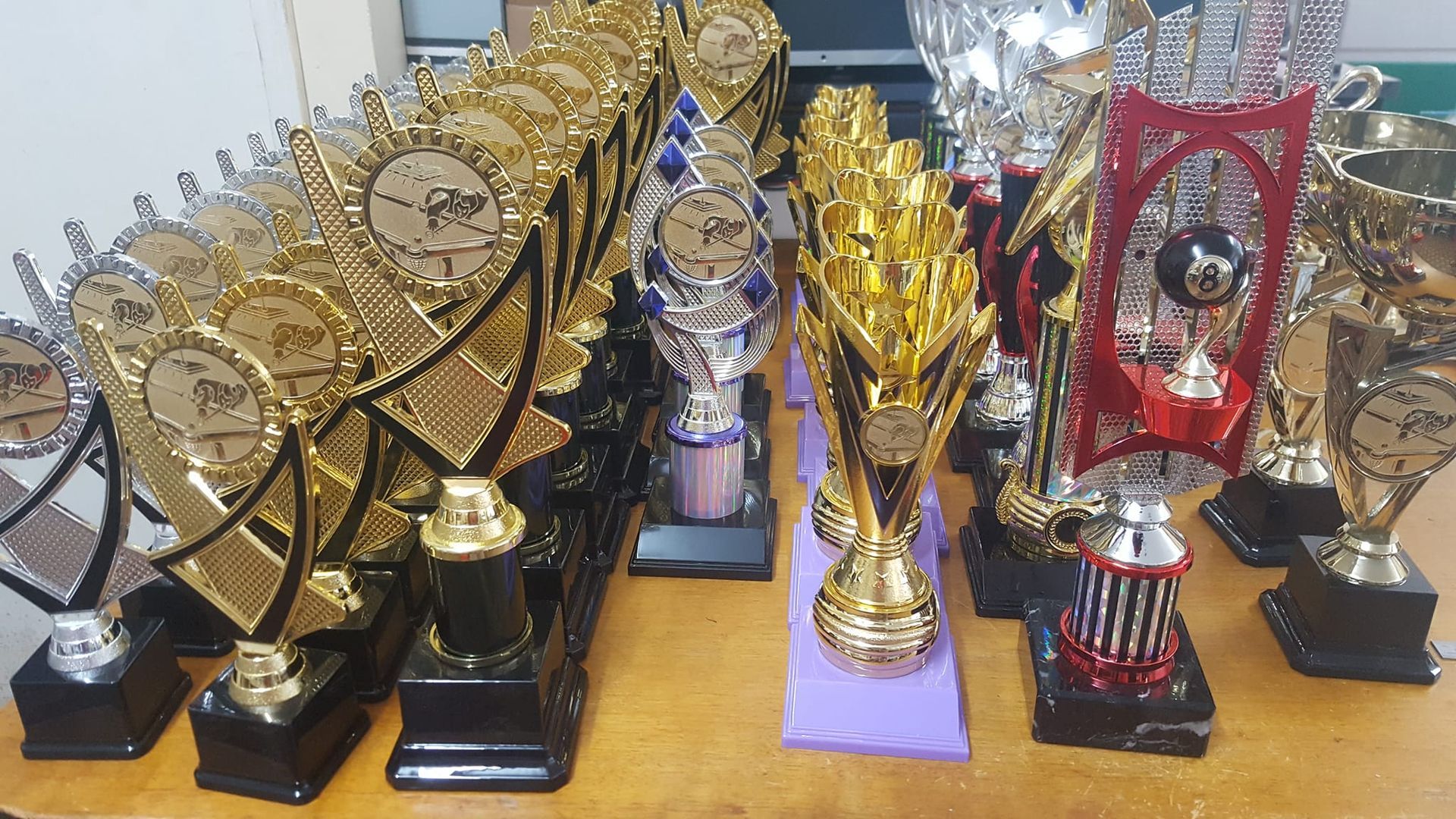 Several trophies are displayed on a table including one that says' winner ' on it