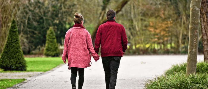A couple enjoying a peaceful walk in a London park, symbolizing connection and shared time.