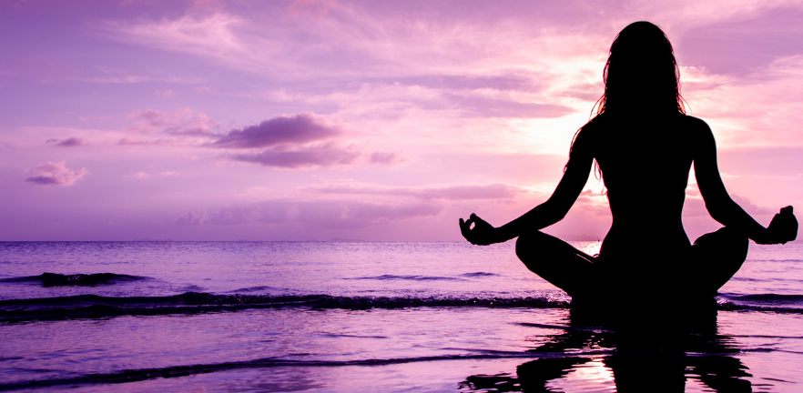 A lady performing a mindful movement at a beach