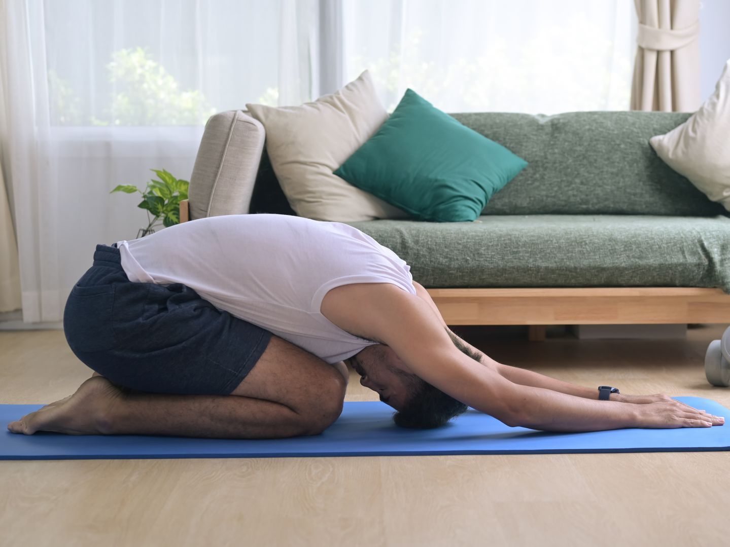 A group of people are laying on yoga mats in a gym.