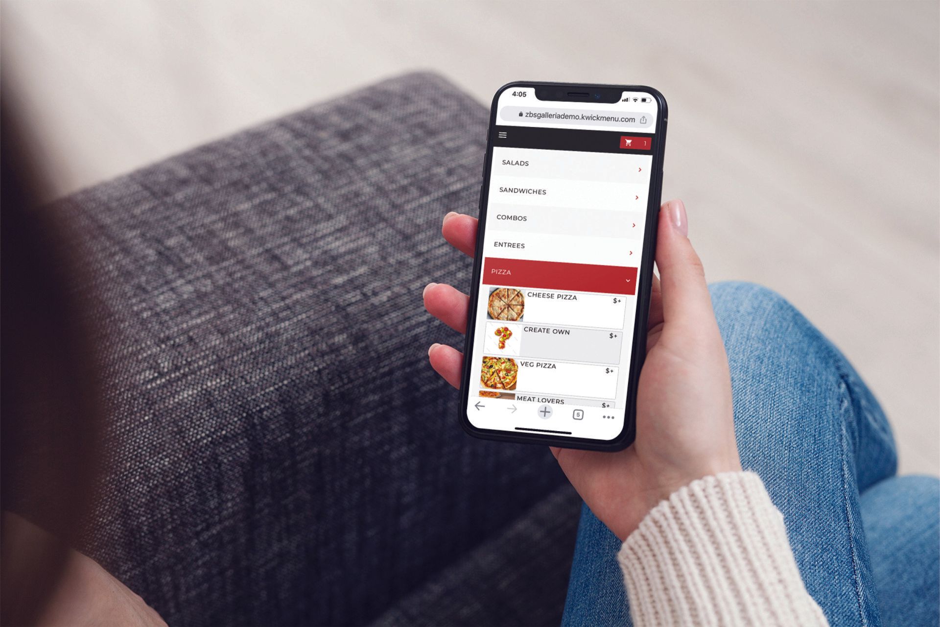 ZBS POS KwickPOS online ordering platform KwickMenu close up of hand holding mobile phone on couch with online ordering menu