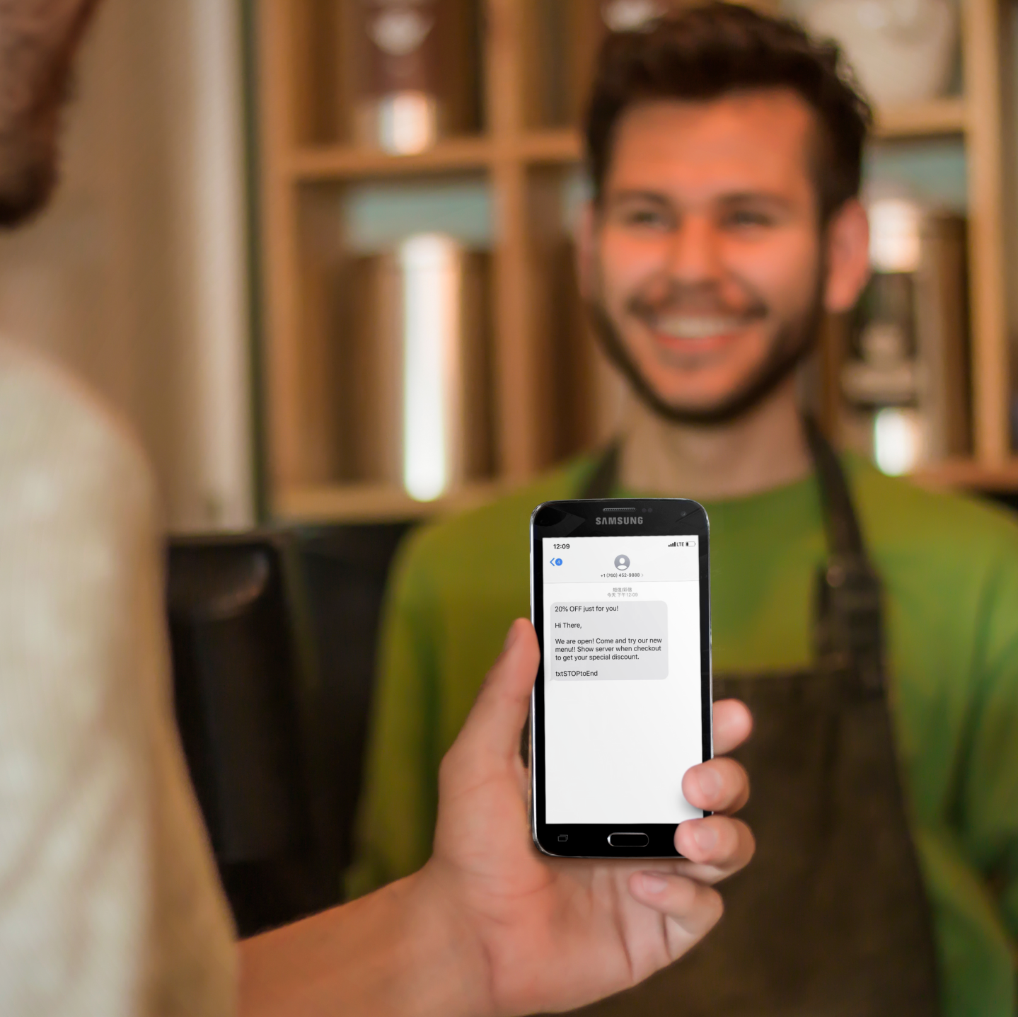 ZBS POS restaurant loyalty program marketing tools man about to show waiter sms text message coupon from phone at cafe