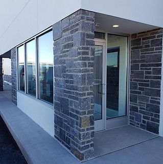 A building with a brick wall and a glass door.