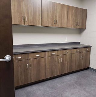 A kitchen with wooden cabinets and a black counter top.