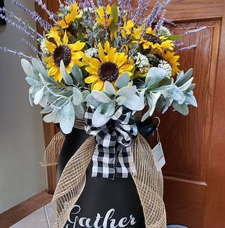 A vase filled with sunflowers and lavender is sitting on a table.