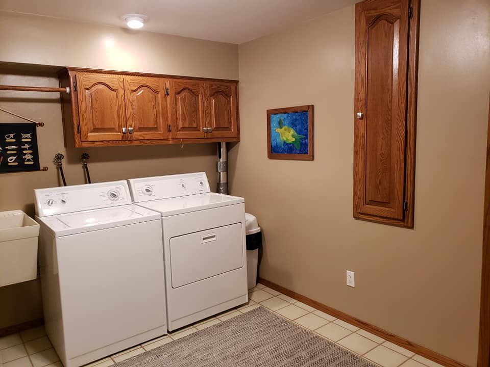 A laundry room with a washer and dryer and a sink.
