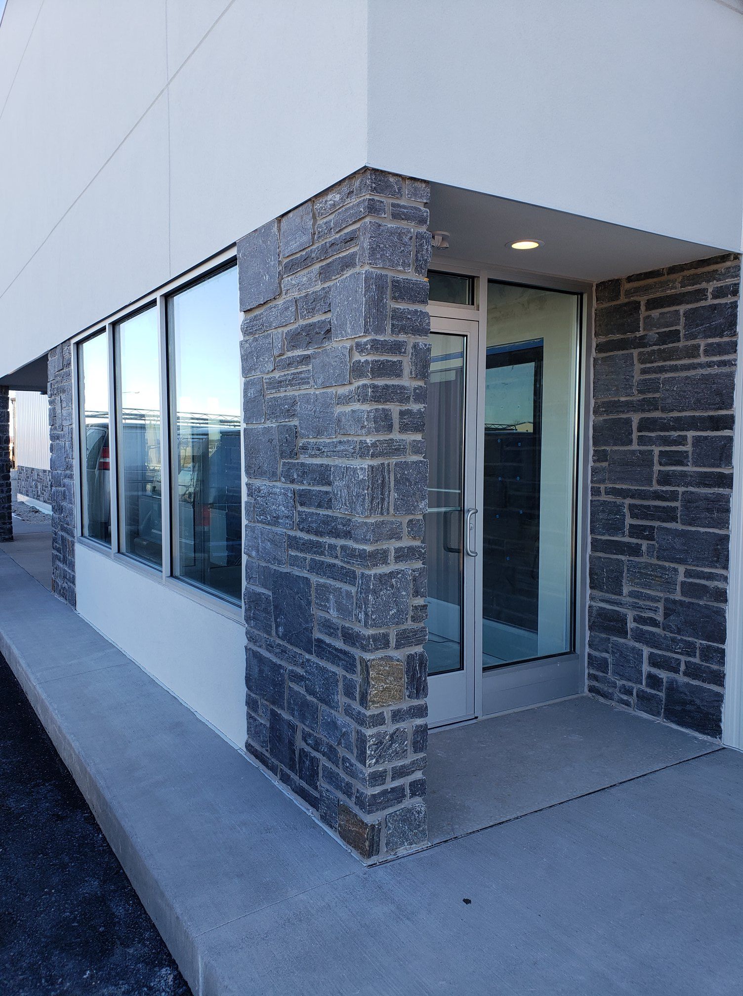 A building with a stone wall and a glass door.