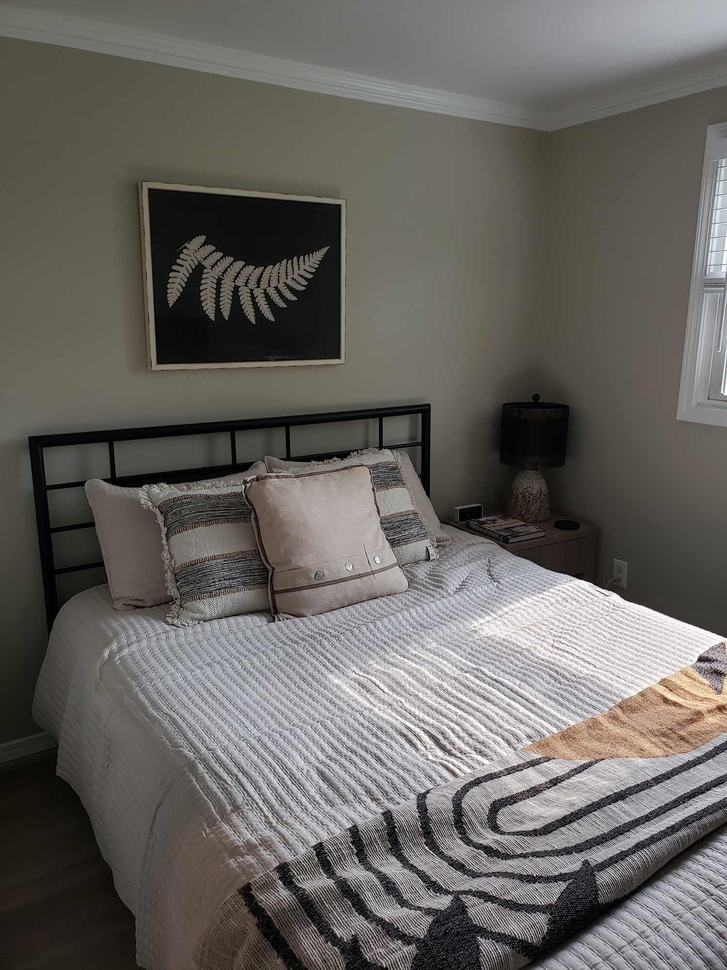 There is a picture of a fern on the wall above the bed.
