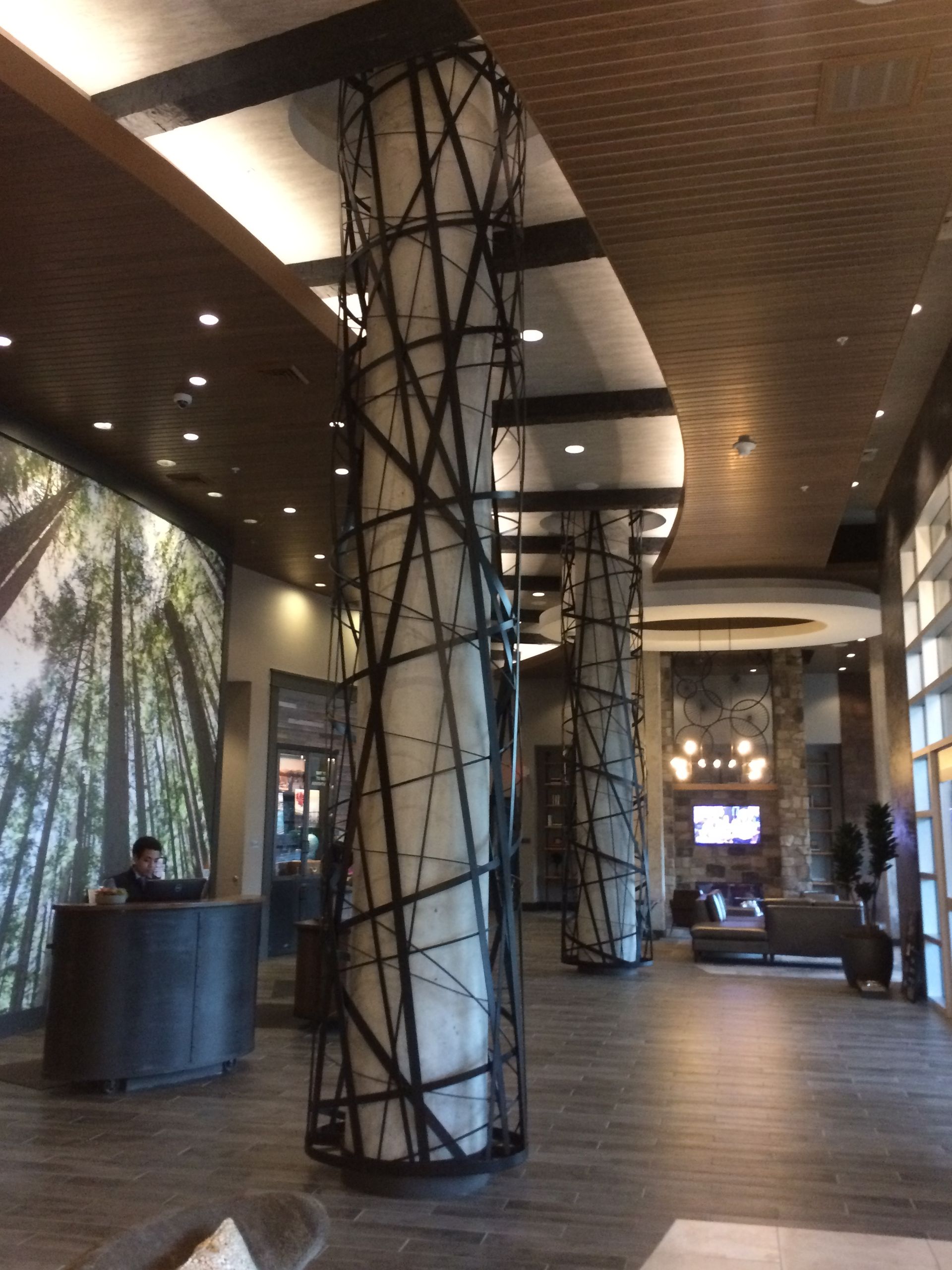 A hotel lobby with a large picture of trees on the wall