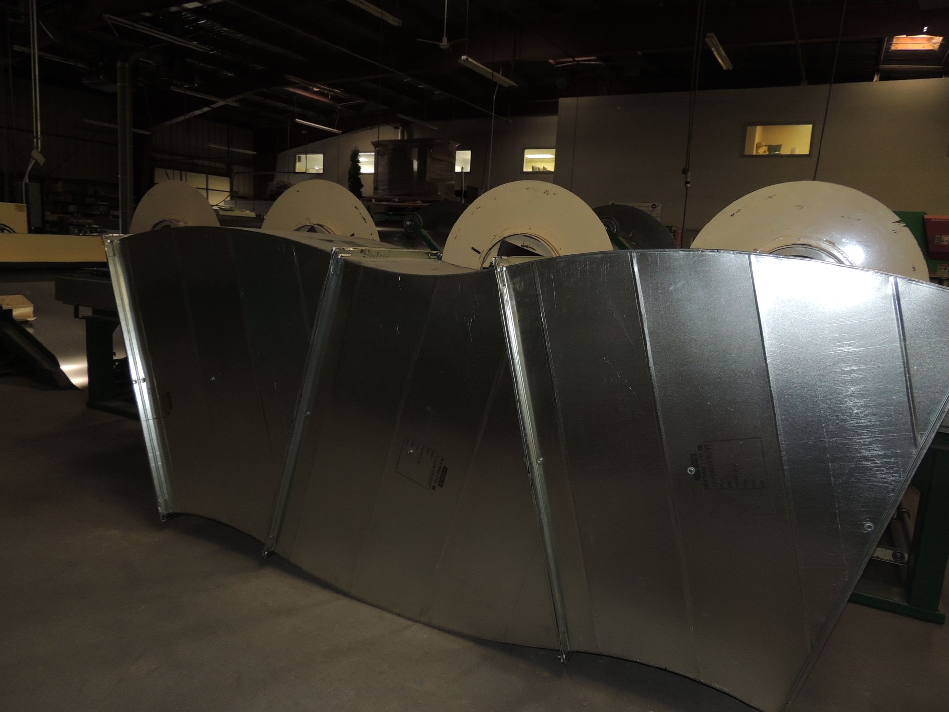 A large metal pipe is sitting in a warehouse.