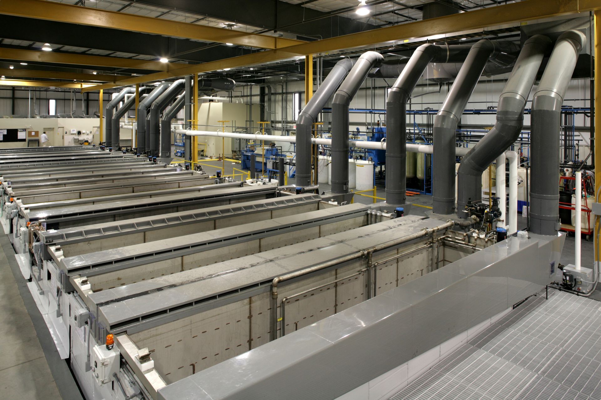 A large warehouse filled with lots of containers and pipes.