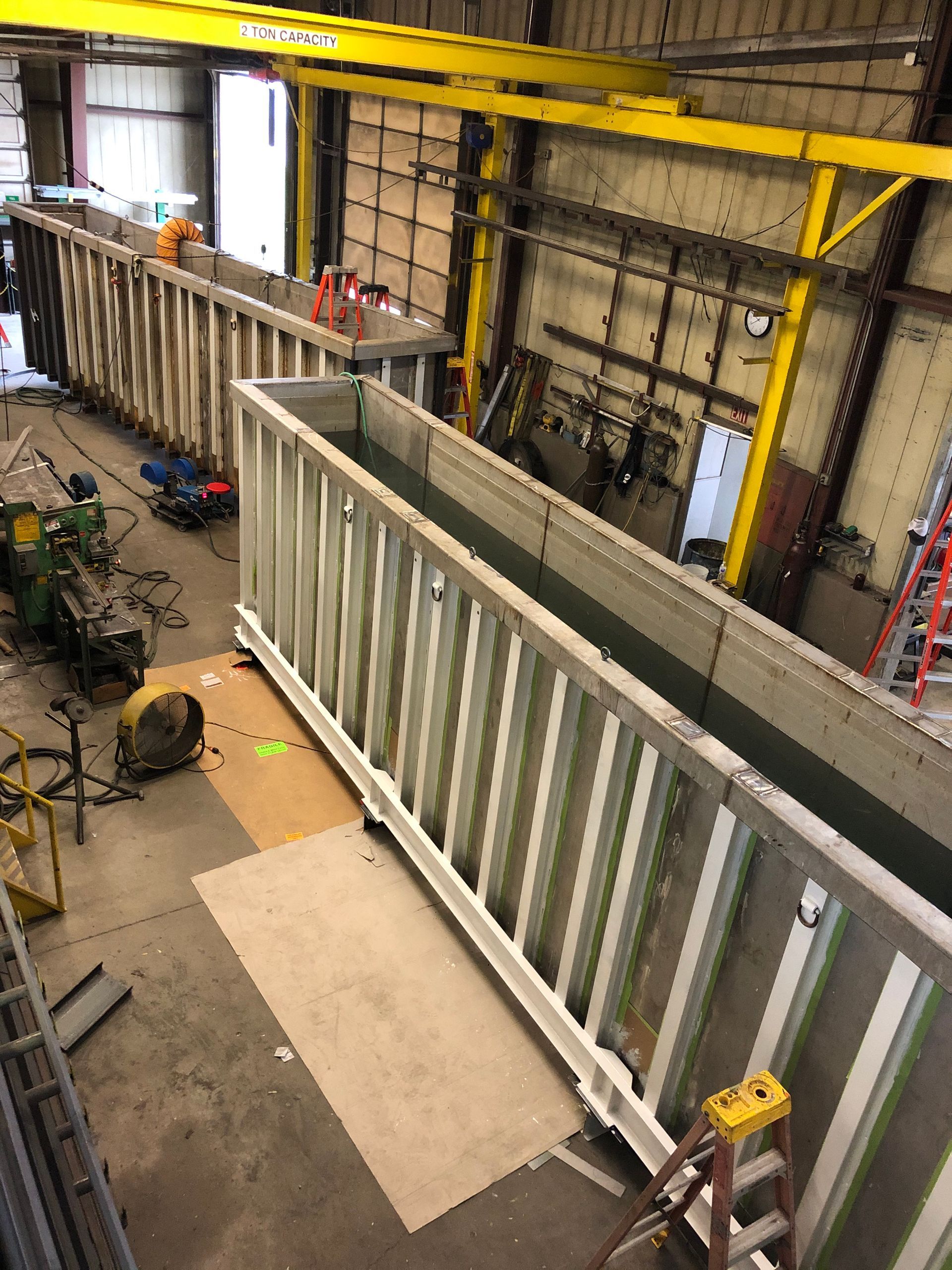 A large white railing is being built in a factory.