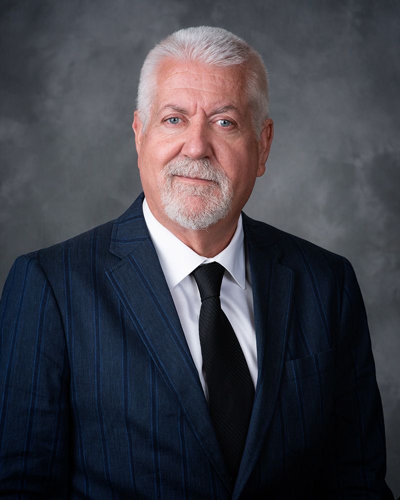 A man named Alan Dykes, wearing a suit and tie.