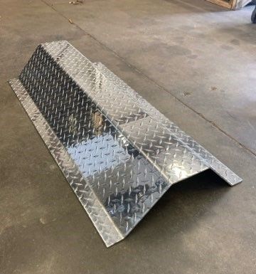 A piece of metal is sitting on a concrete floor.
