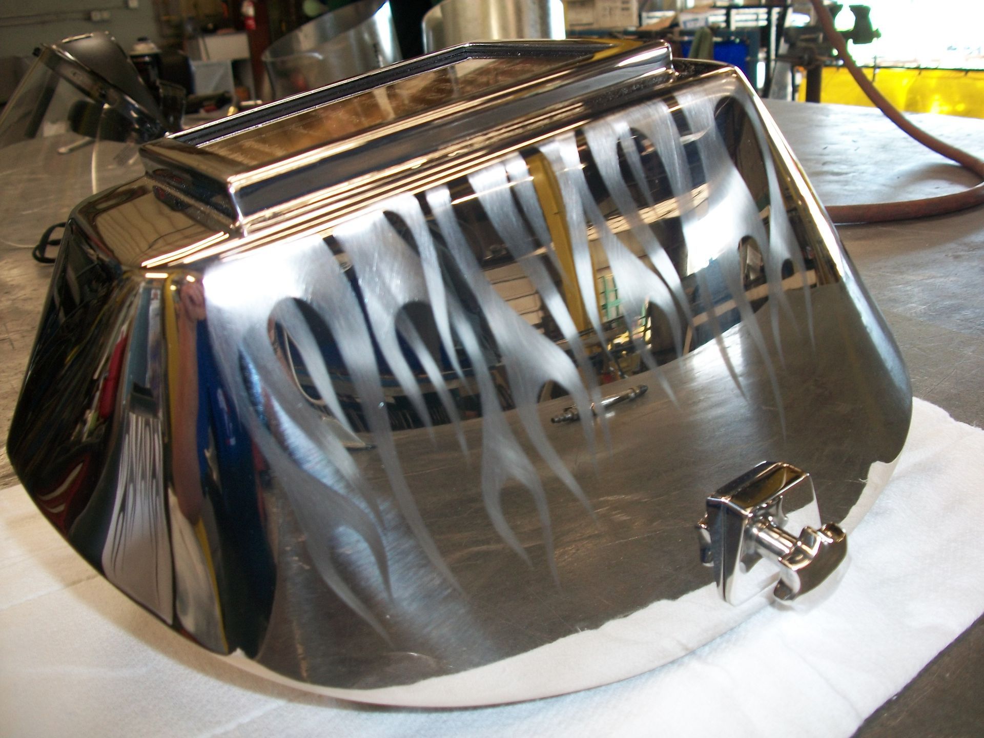 A chrome item with flames painted on it