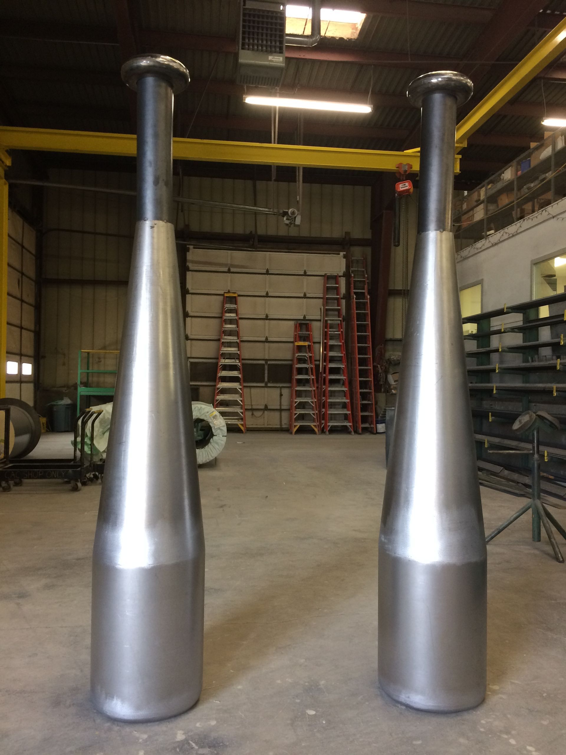 Two large metal pipes are sitting in a warehouse