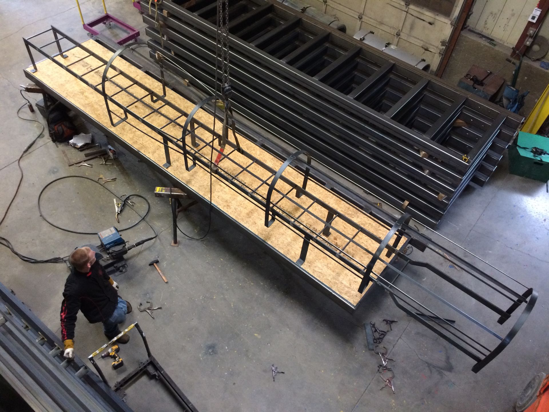 A man is working on a metal structure in a factory