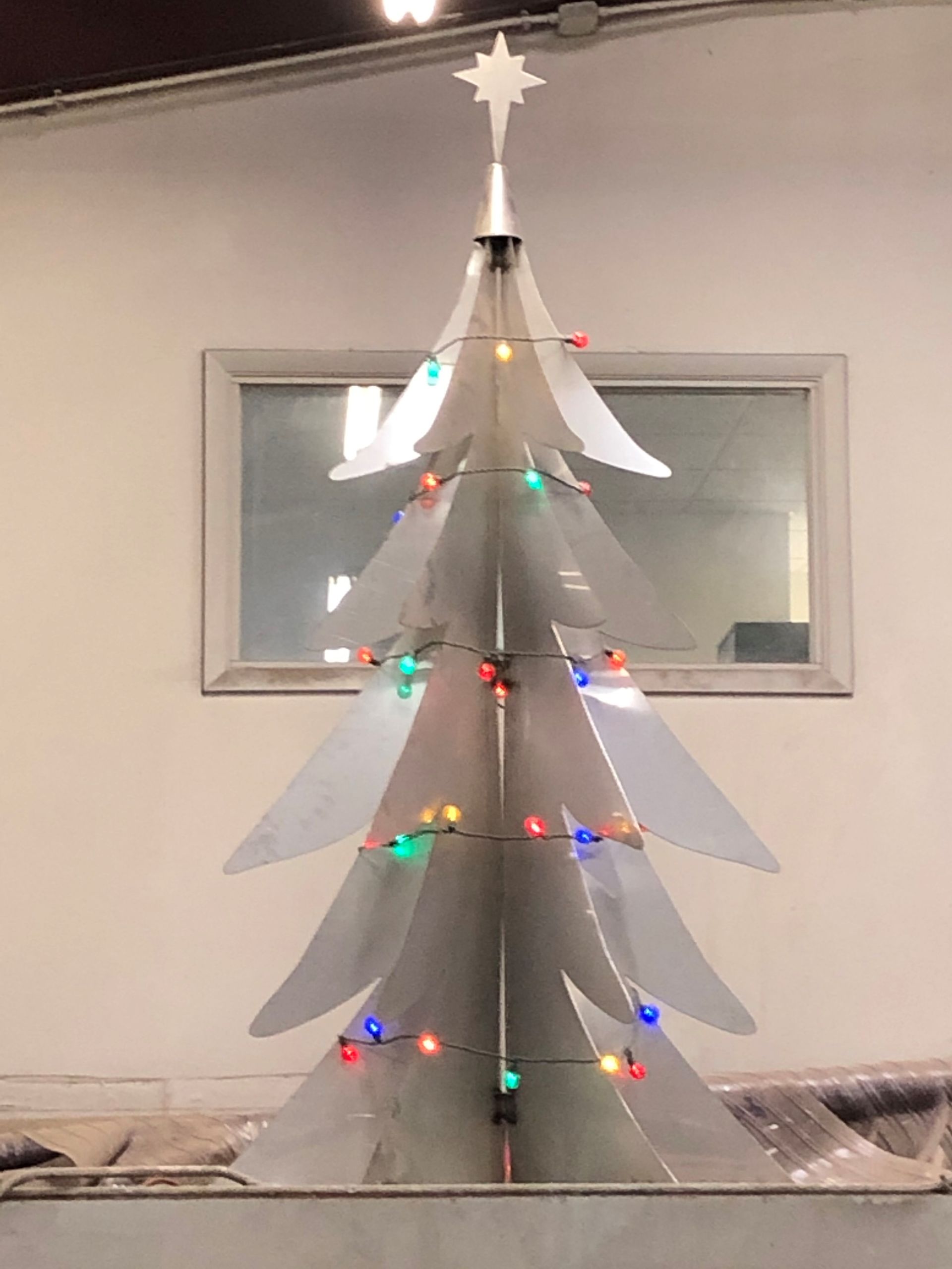 A cardboard christmas tree with lights and a star on top