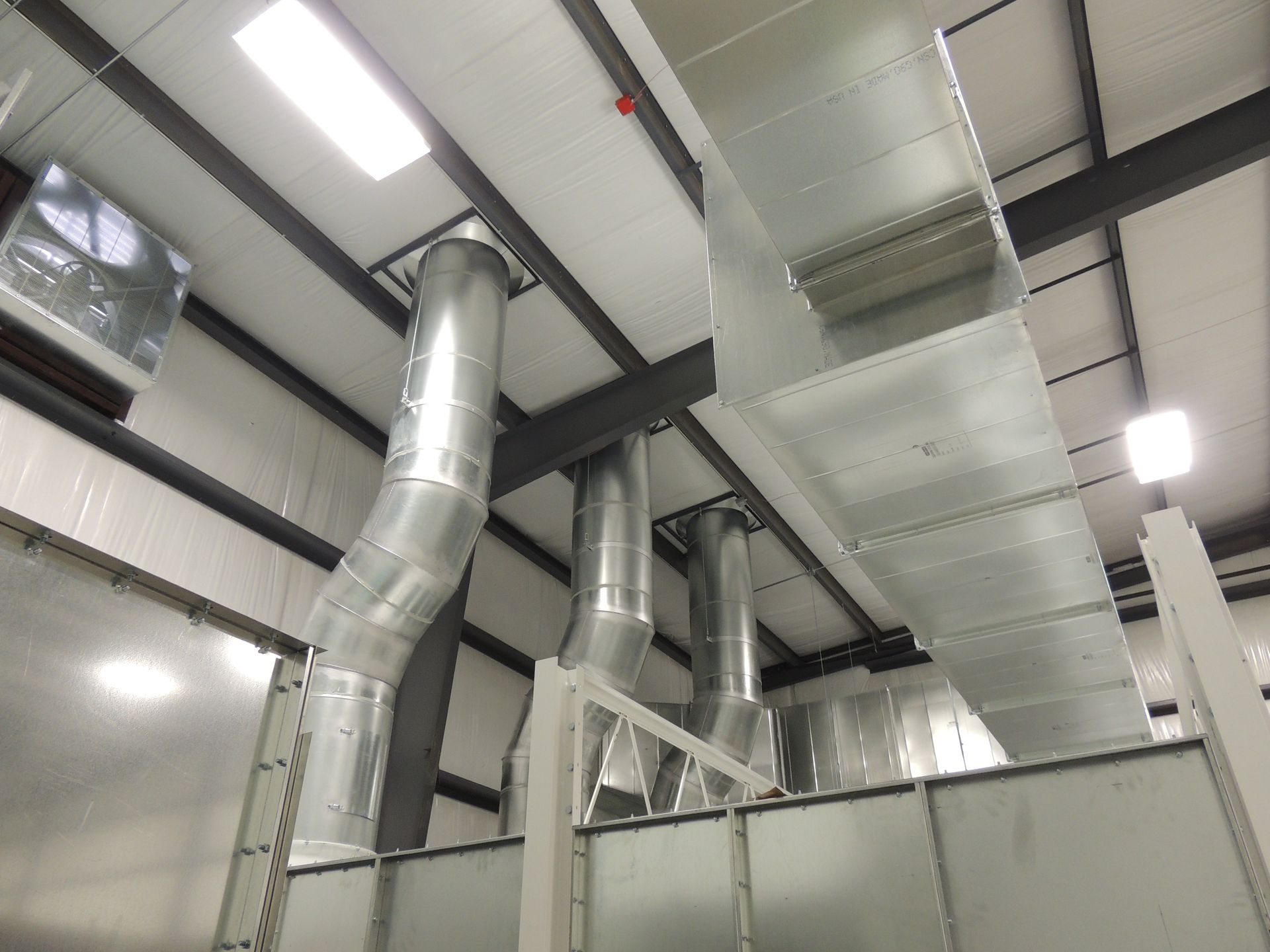 A large metal pipe is hanging from the ceiling of a building.