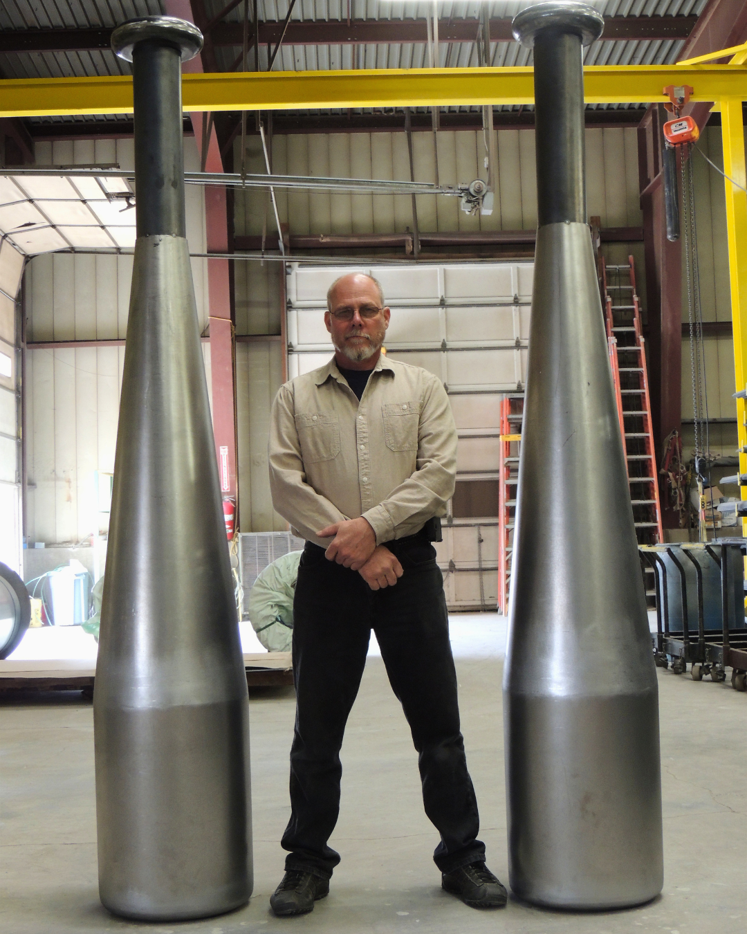 Picture of Central Employee with larger than life sized baseball bats designed by Custom Fabrication