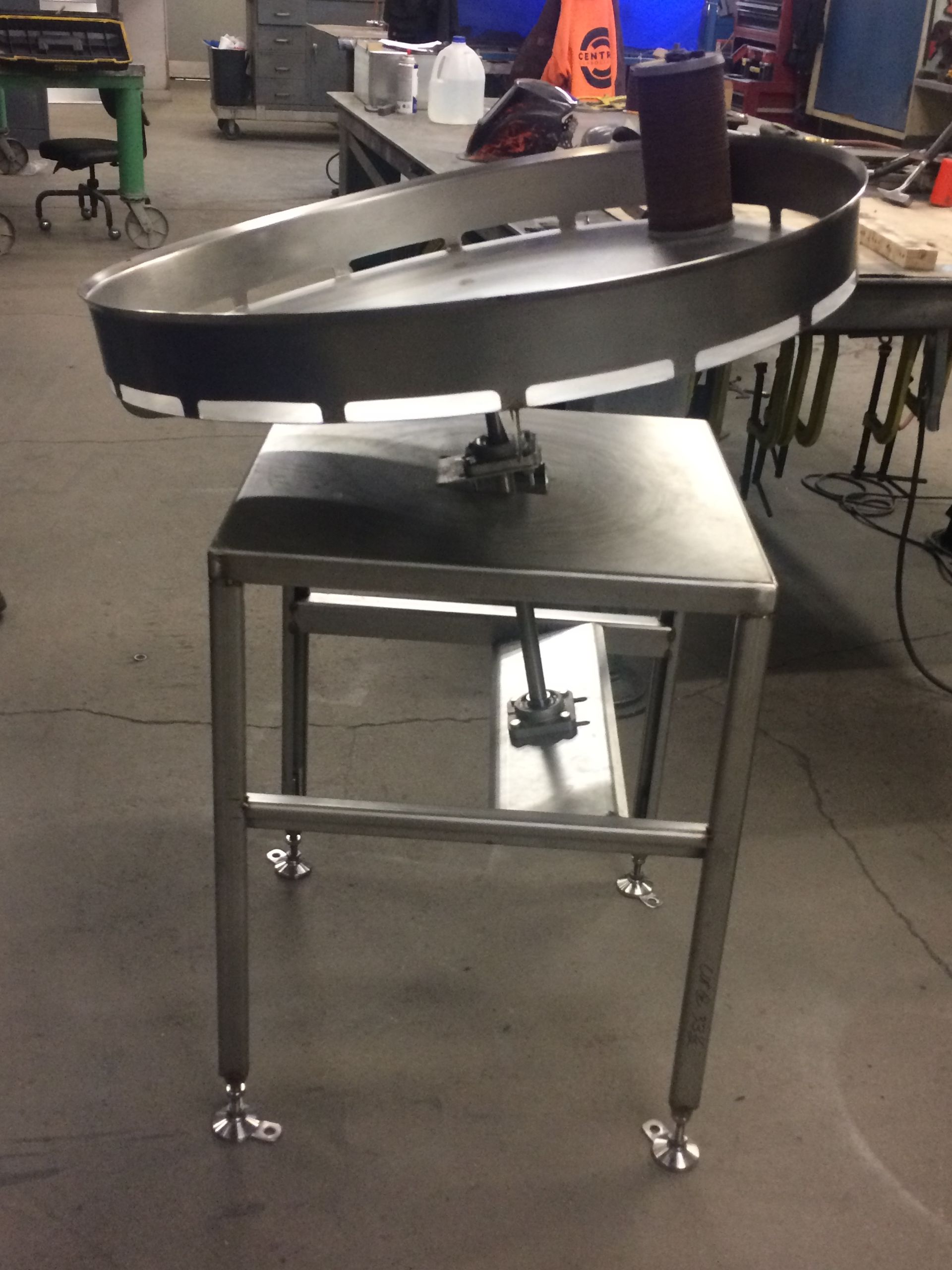 A stainless steel conveyor belt is sitting on top of a metal table