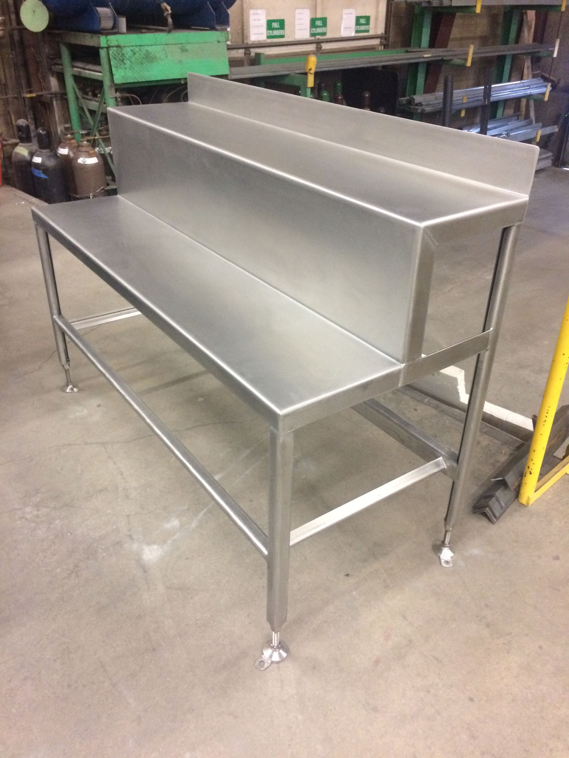 A stainless steel table with a shelf underneath it