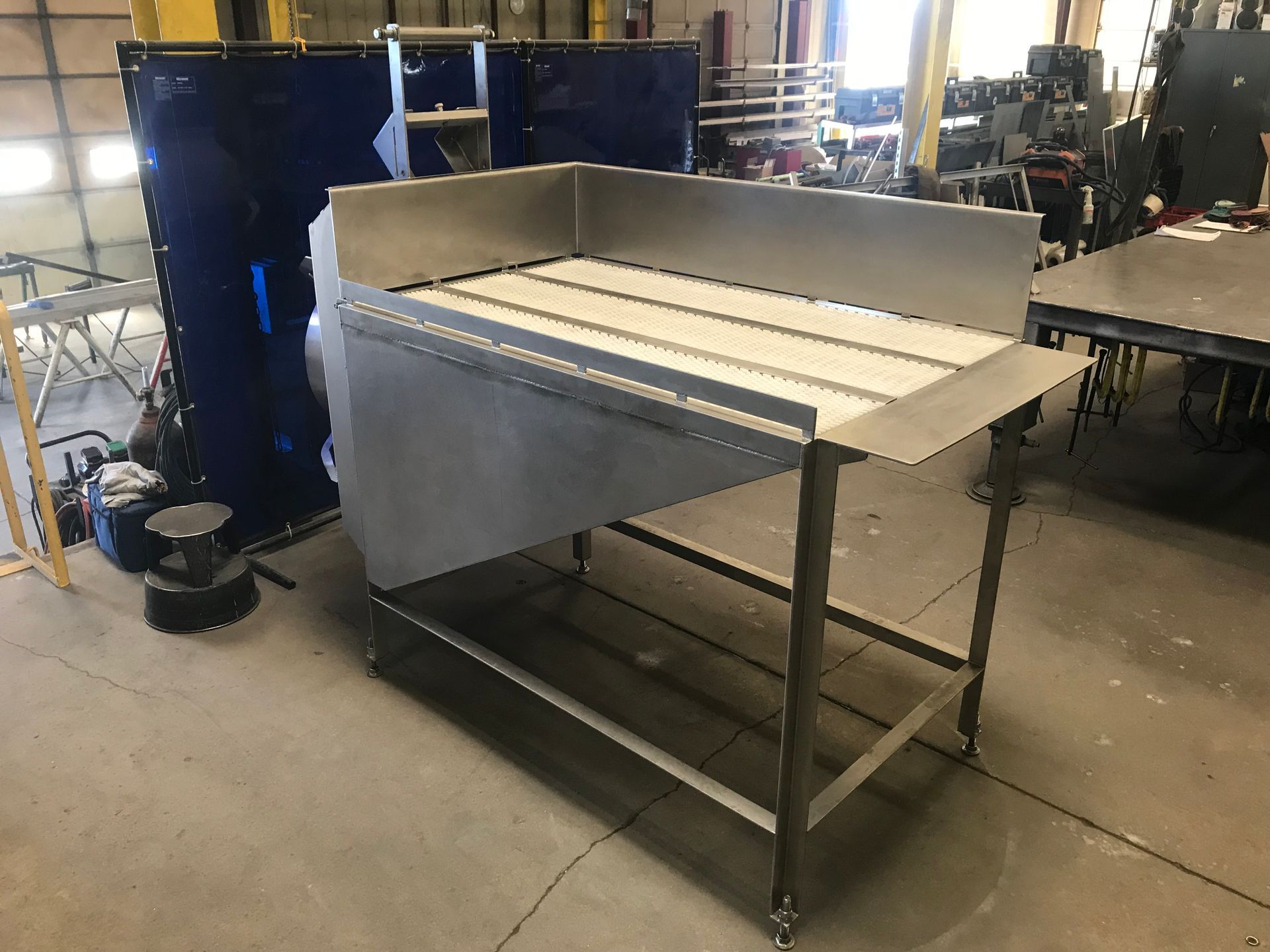 A stainless steel table is sitting in a warehouse.