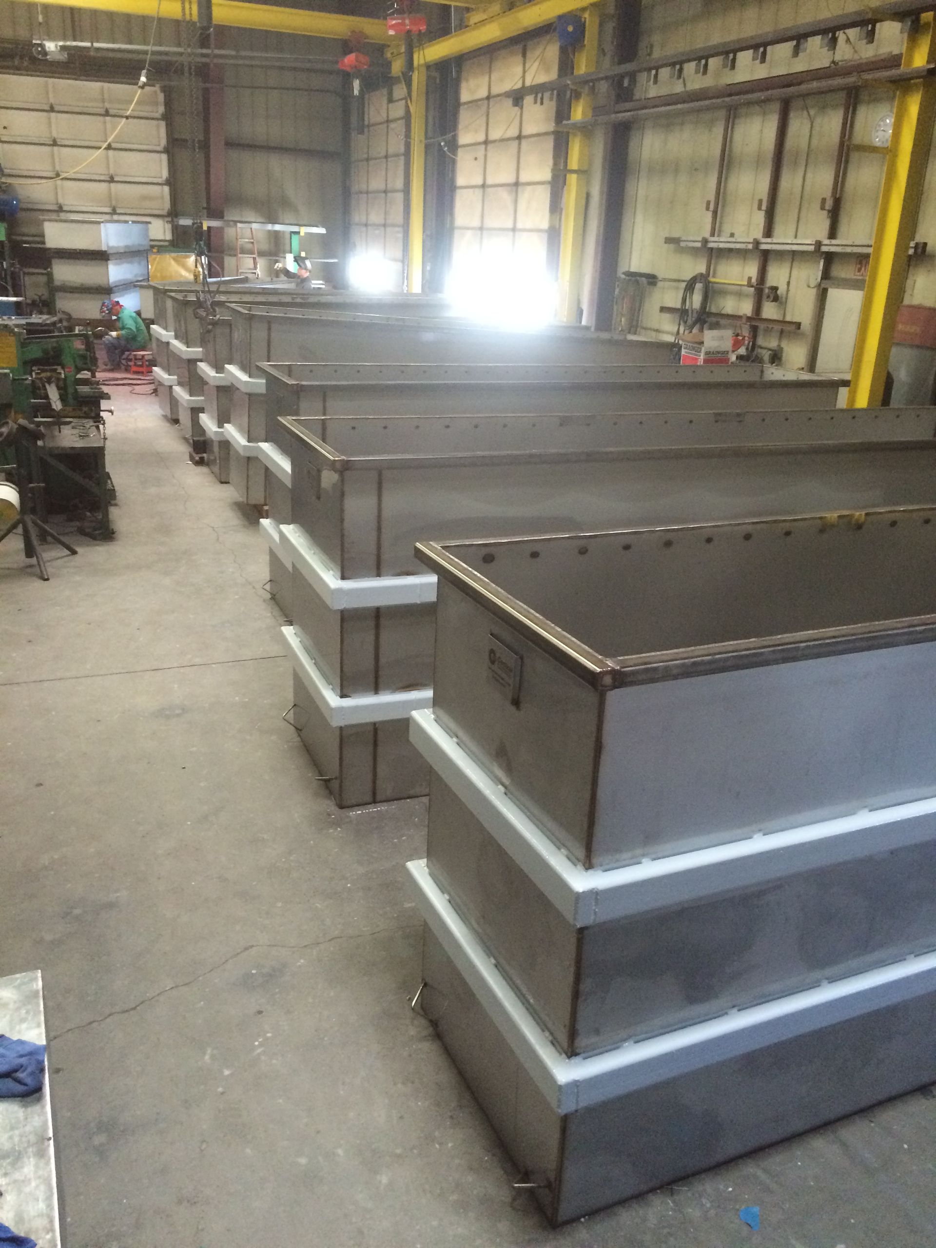 A row of stainless steel containers are stacked on top of each other
