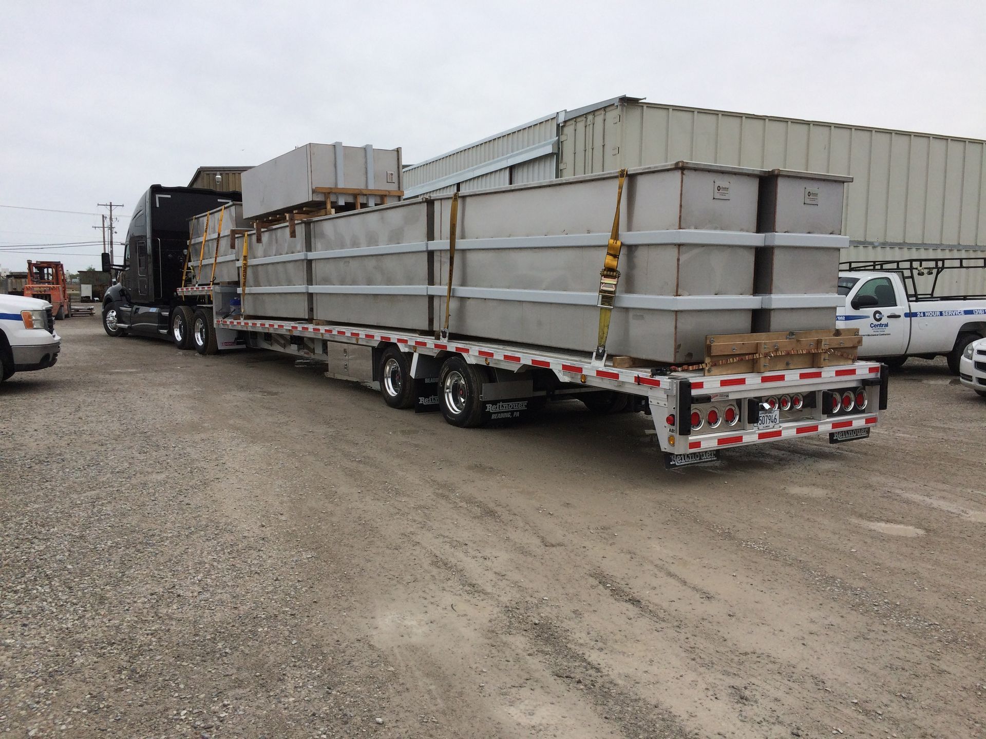 A semi truck is carrying concrete blocks on a trailer.