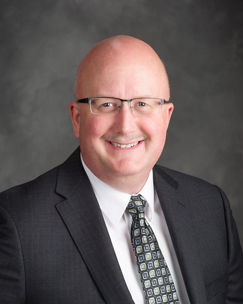 A man in a suit and tie is smiling for the camera.