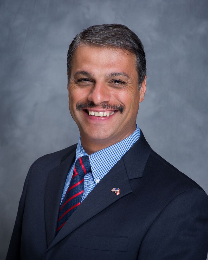 A man in a suit and tie is smiling for the camera.