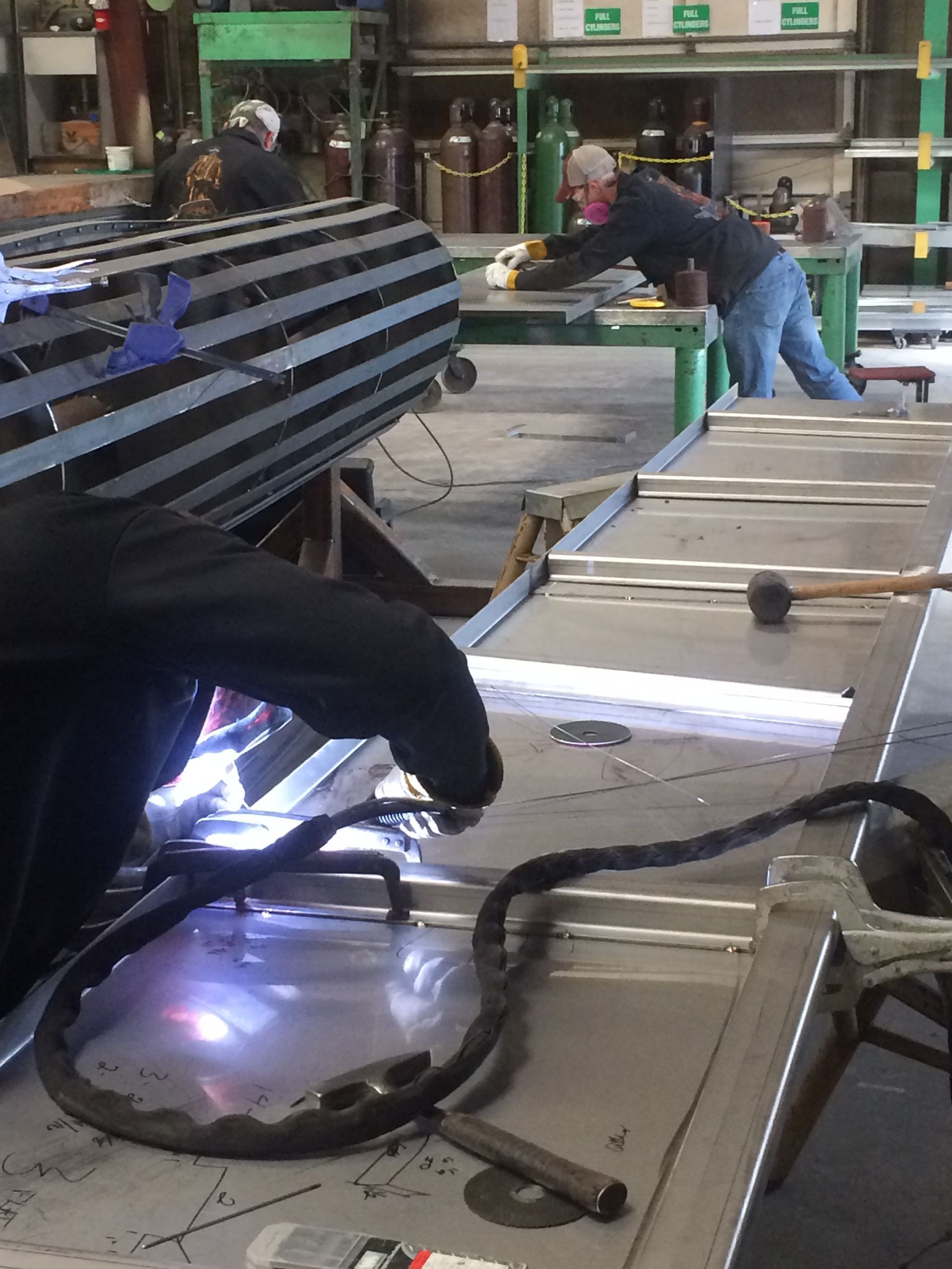 A man is welding a piece of metal in a factory