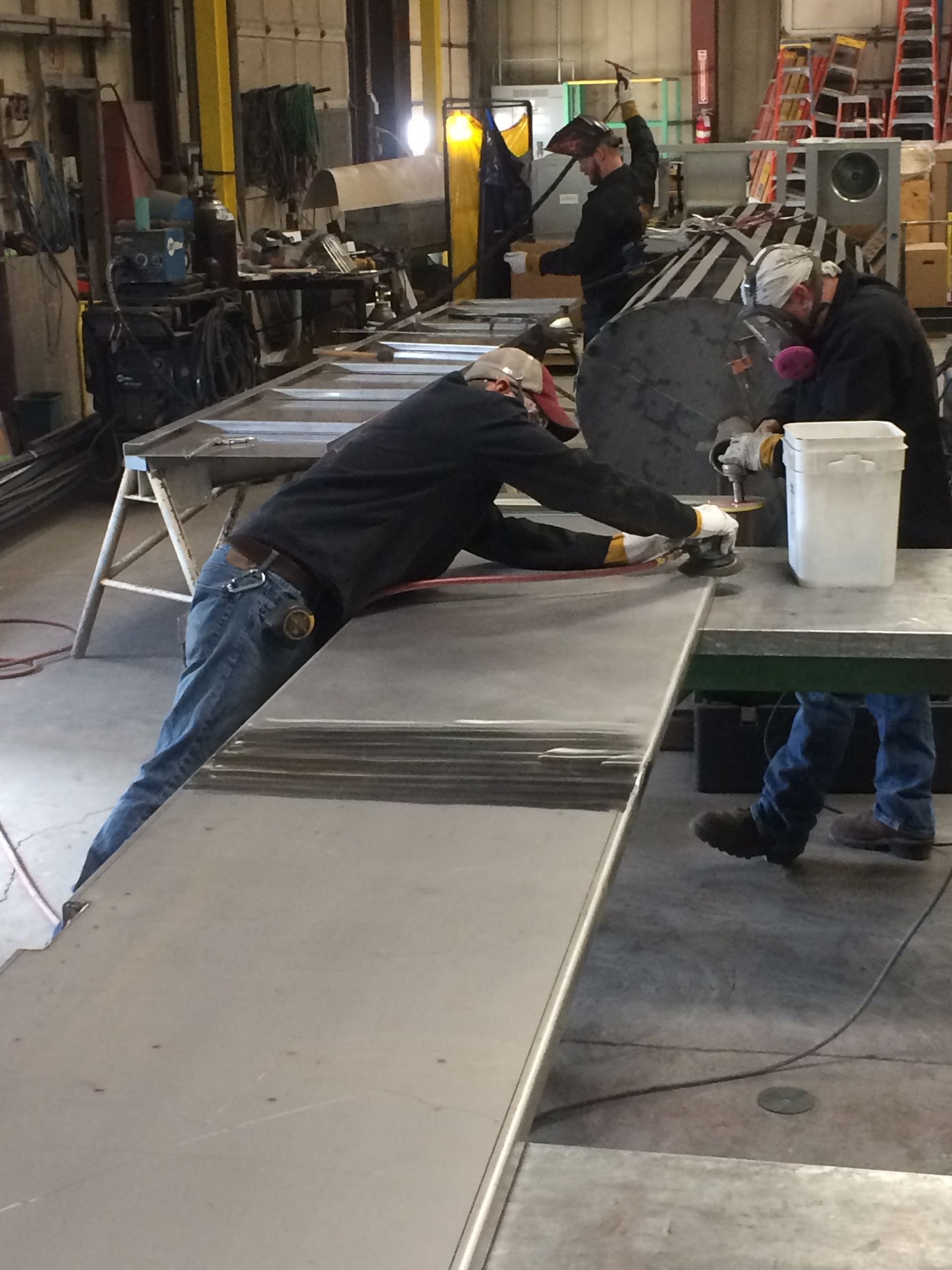A man is working on a piece of metal in a factory