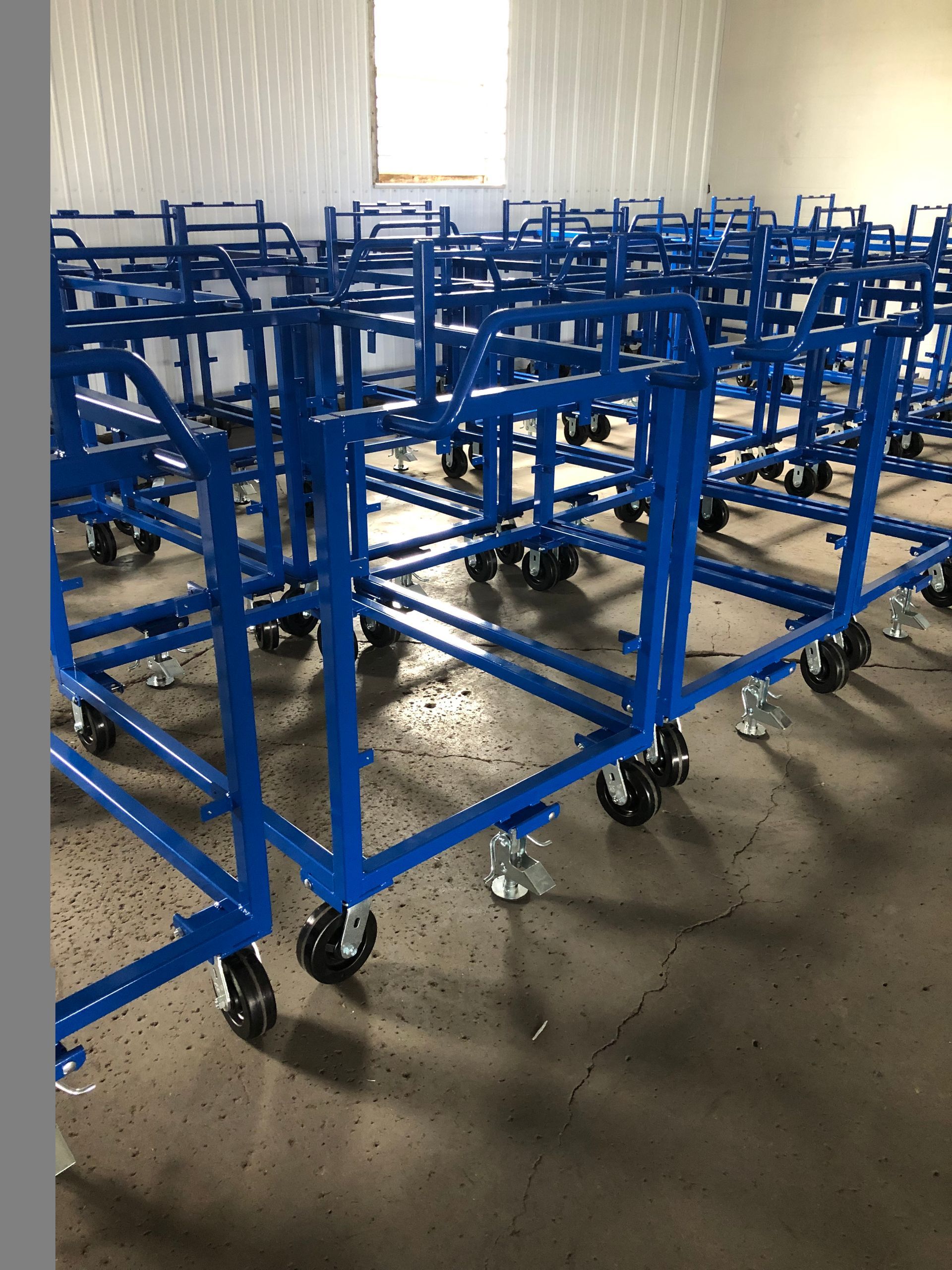 A bunch of blue carts are lined up in a room